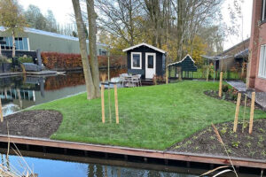 Van Vliet Hoveniers - Fraaie tuin aan het water met toegangsbrug